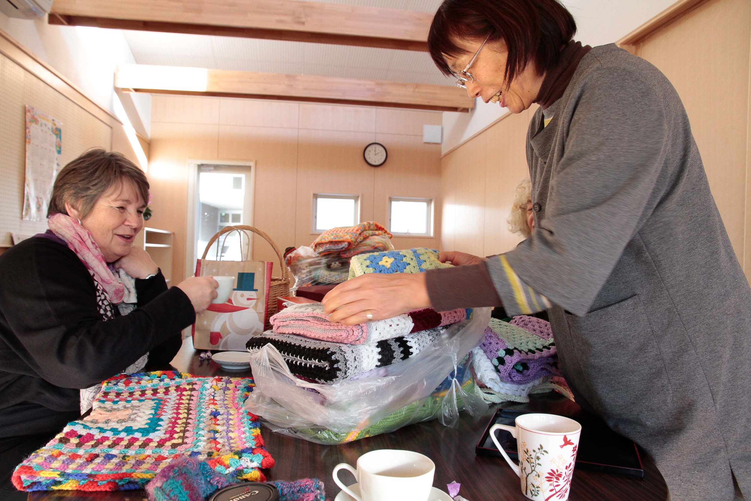 Mrs Utsumi, founder of the Mother's Home, looking at all the beautiful blankets.