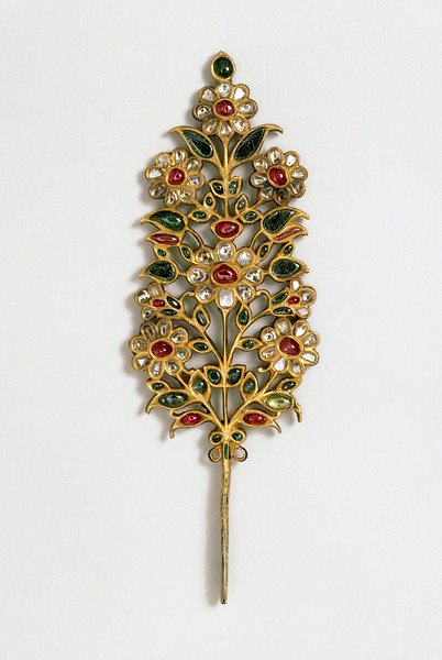 Sprays of flowers turban jewel. Once belonged to the Maharaja of Jaipur. The aigrette is set with rubies, emeralds and pale beryls on one side, and the same stones with the addition of diamonds on the other. The stem and the sides of the jewel are enamelled in translucent green.