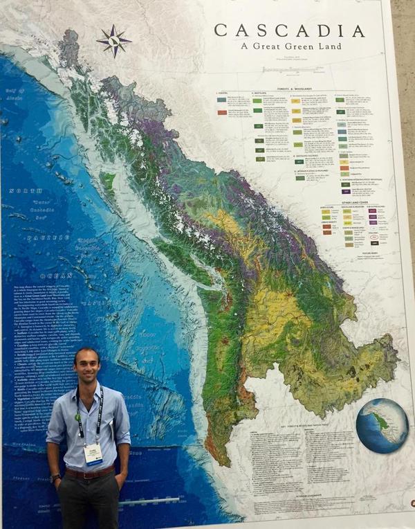 Cody Camarata stands in front of a massive blowup of David McCloskey's new Cascadia Bioregion map - 'Cascadia a Great Green Land'. In all more than 15,000 people had the chance to see the map at this years 2015 ESRI User Conference at UC San Diego, July 20th-24th. Awesome photo by Alex Philip @BigDataAlex on twitter! 