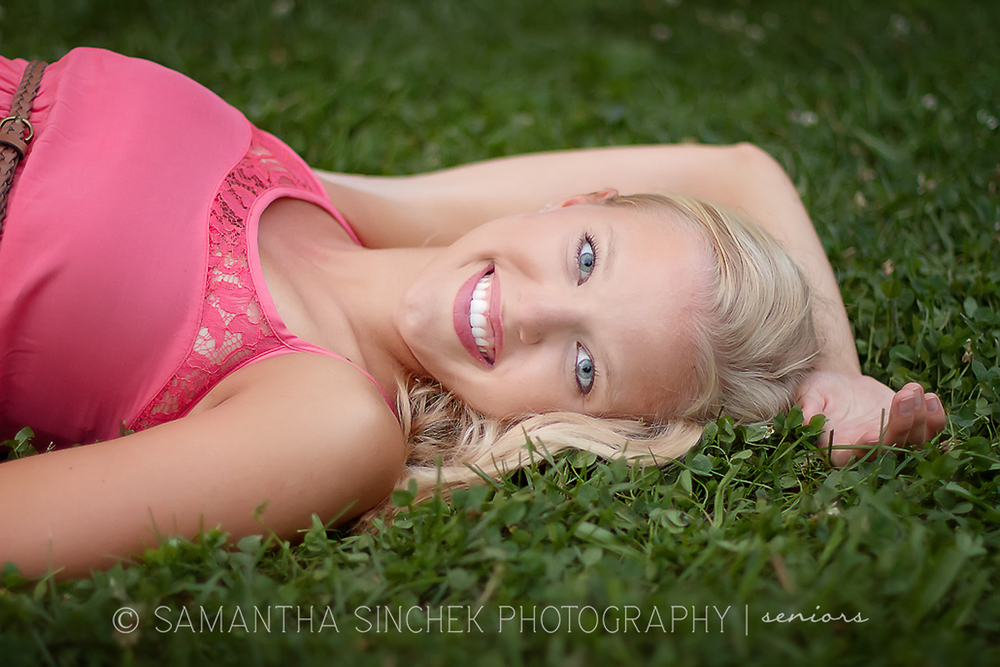 girl lying in grass during senior portrait session at ault park in cincinnati ohio