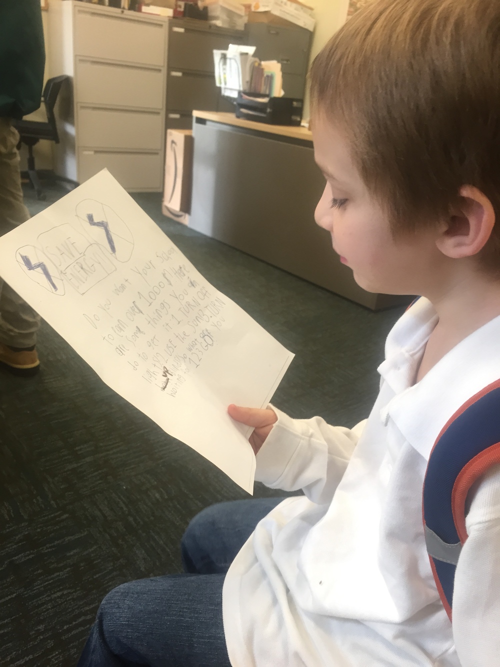A student at Maury Elementary School reads an afternoon energy announcement that he composed. 