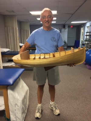 Patient William Hargrove proudly stands with a model boat he made.