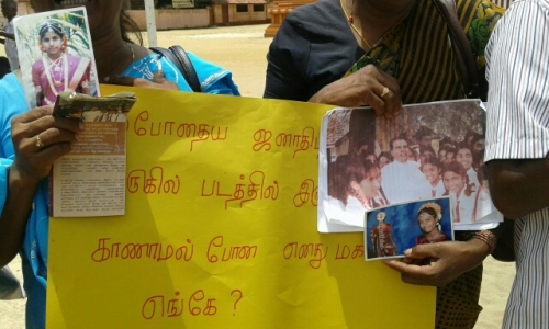 at a july demonstration in jaffna, a tamil Mother holds photographs of missing daughter alongside a sign reads, "Where is my missing daughter who is in this photograph next to the current president." image by Tamilwin, courtesy of tamil guardian.