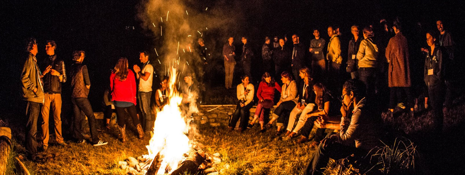 Web of change participants around bonfire.