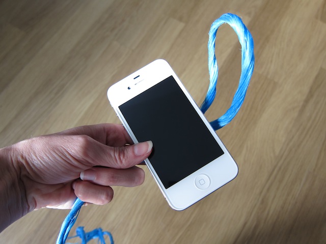 Take a loop of string and secure it around your smartphone in girth hitch