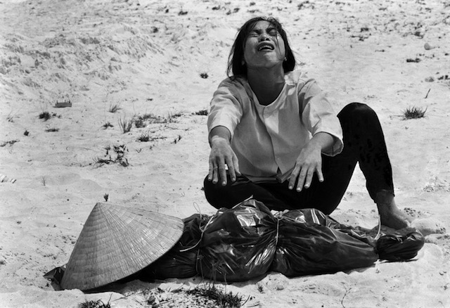 A woman mourns over the body of her husband after identifying him by his teeth, and covering his head with her conical hat. The man’s body was found with forty-seven others in a mass grave near Hue, April 11, 1969. The victims were believed killed during the insurgent occupation of Hue as part of the Tet Offensive. (AP Photo/Horst Faas)