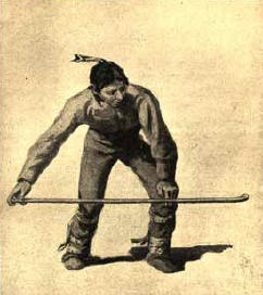 American Indian hurtling a snow snake.