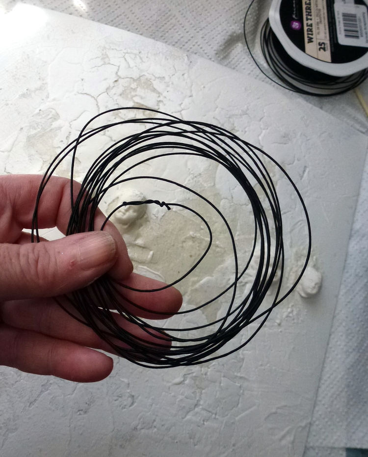 Create a photo frame using wire thread, begin by forming multple loops and then bend into the shape of a heart, attach to back ground using a stapler  