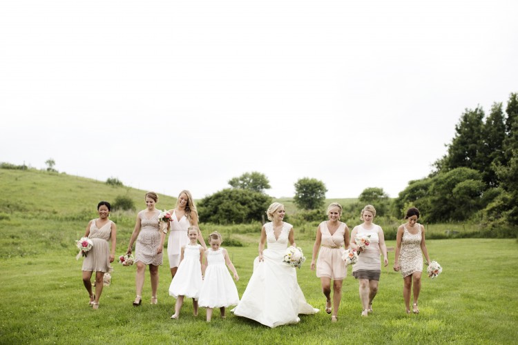 Wedding bridal party walking in grass field