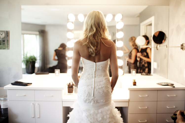 bride looking at herself in wedding dress in a mirror