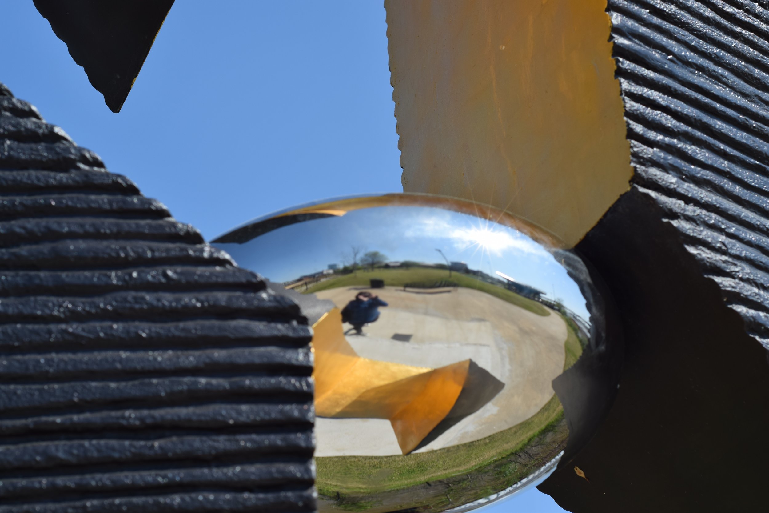 photo by emily reeves dean of a reflection in a sculpture in little rock riverfront park