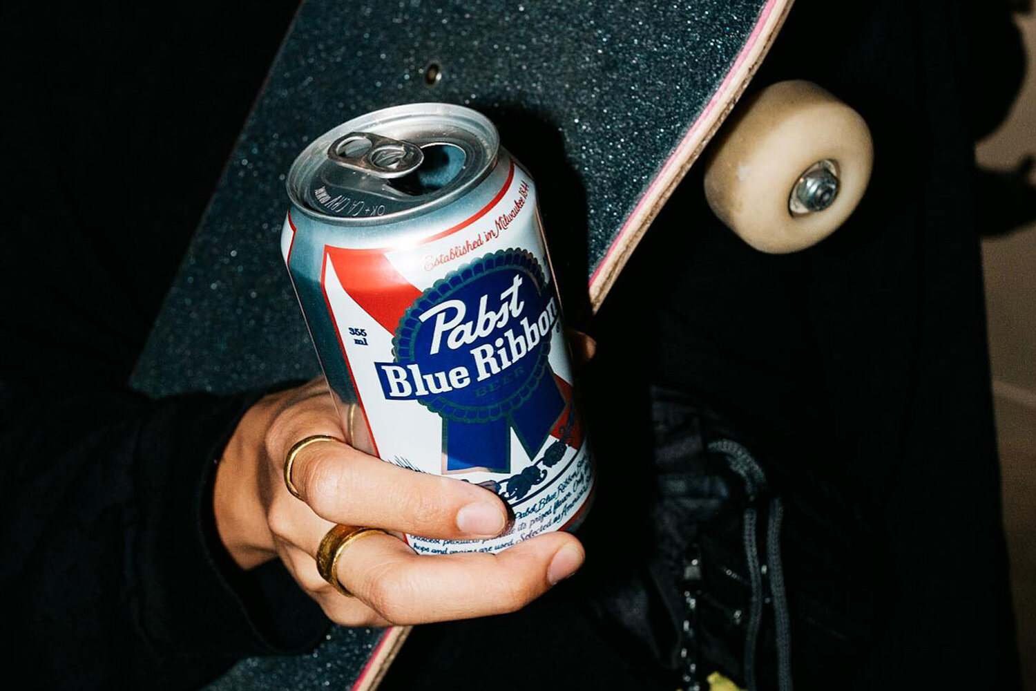 A hand holding a pabst blue ribbon beer.