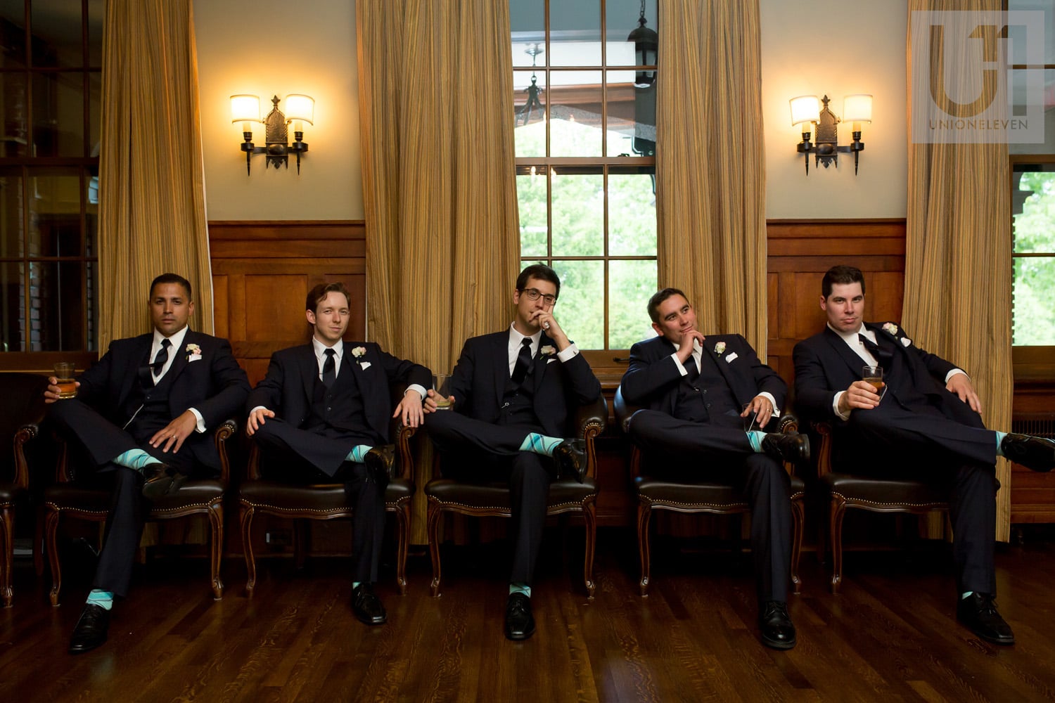 groomsmen sitting on chairs pensively at the Royal Ottawa Golf Club during wedding reception