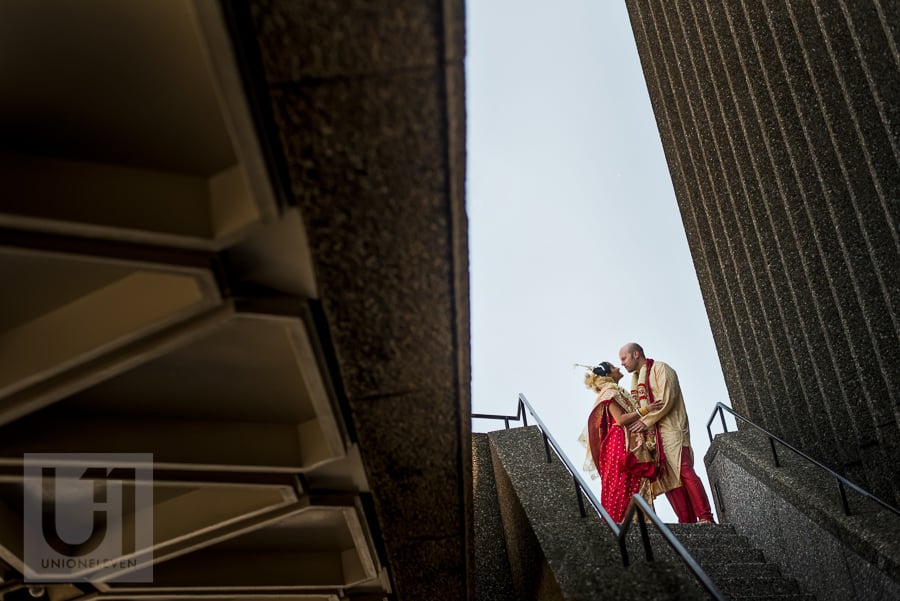 portrait of bride and groom in traditional Hindu dress, on staircase in downtown Ottawa