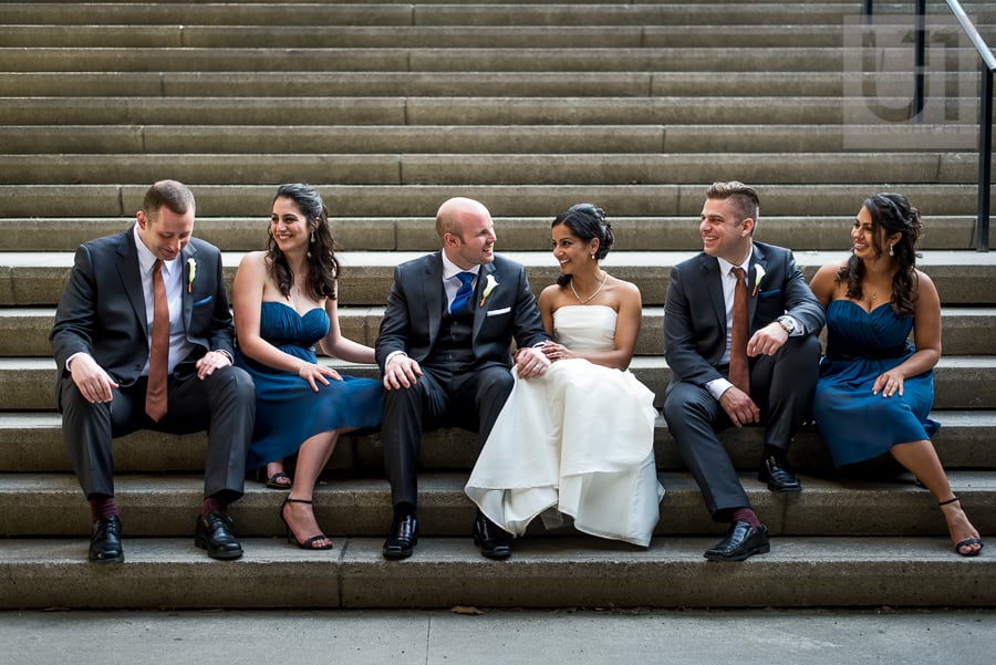 casual portrait of wedding party sitting on steps in downtown Ottawa