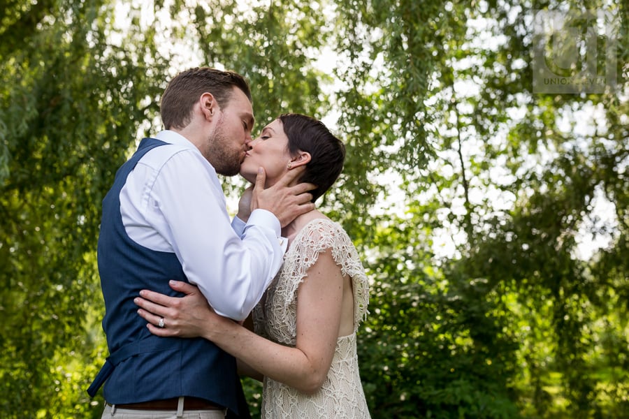 Groom kisses bride for the first time as married couple at the Arboretum in Ottawa.