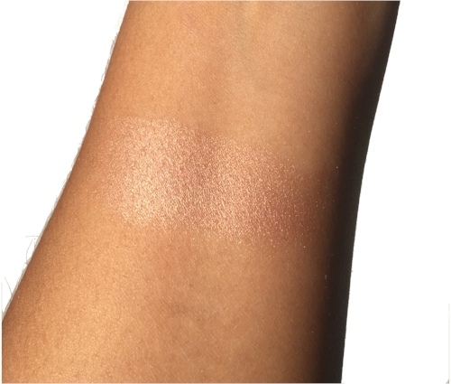 Swatch of the Blushed Gems Baked Highlighting Powder in direct sunlight. 