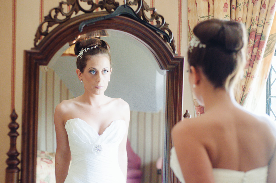 Bride looking in mirror - Groomsmen - Eastwell Manor Wedding Photographer