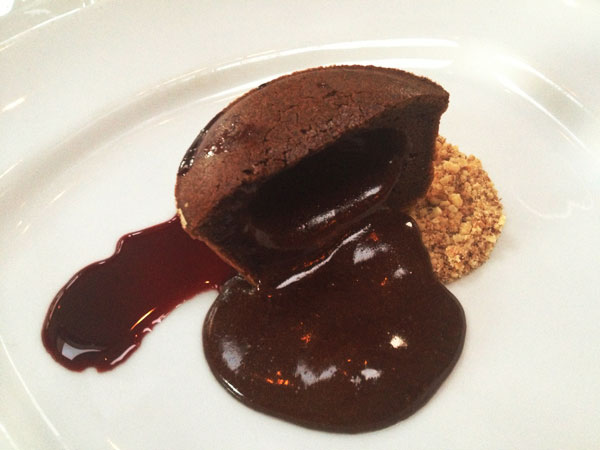 Light Bistro - Warm Chocolate Cake filled with chocolate sauce and served with crushed walnuts and grape syrup