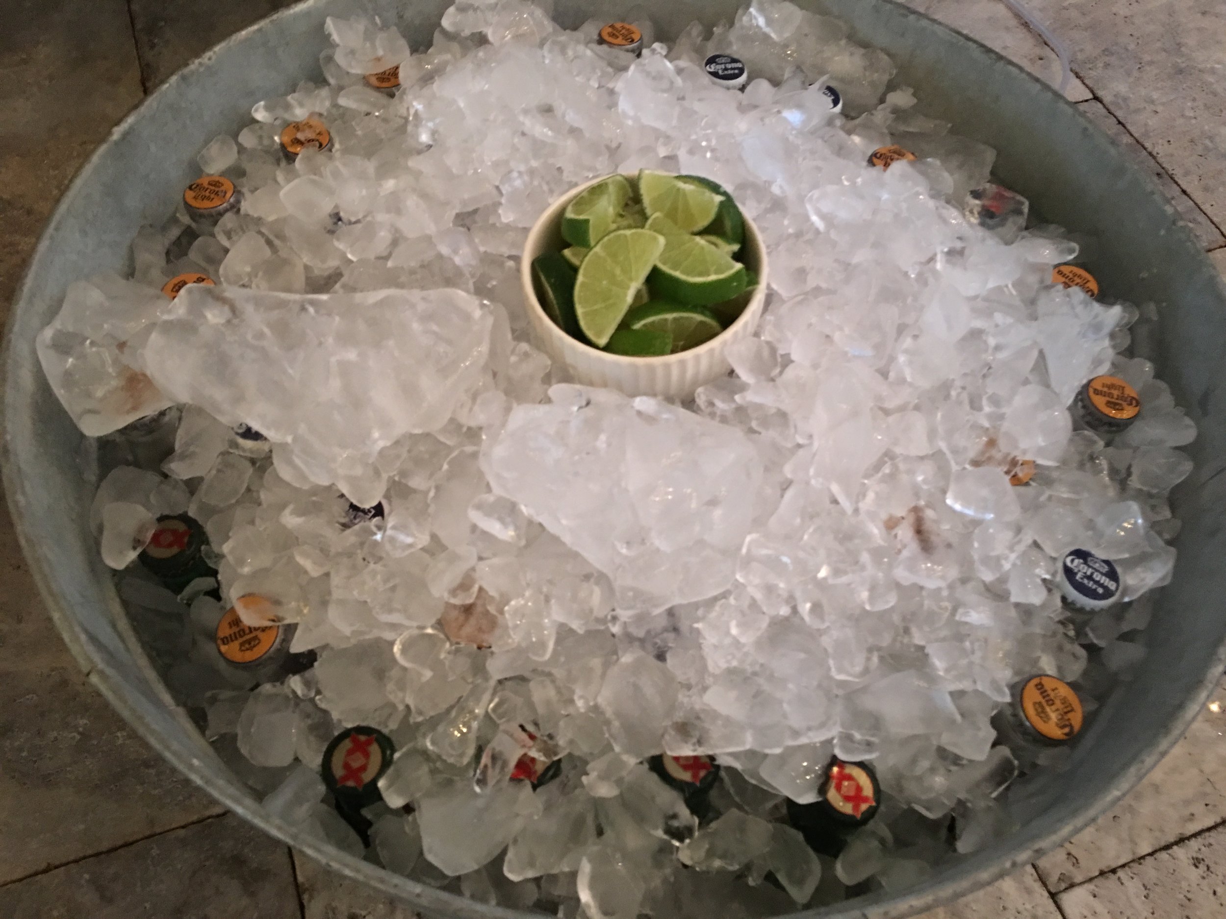  Galvanized bucket with beers on ice and lime wedges 