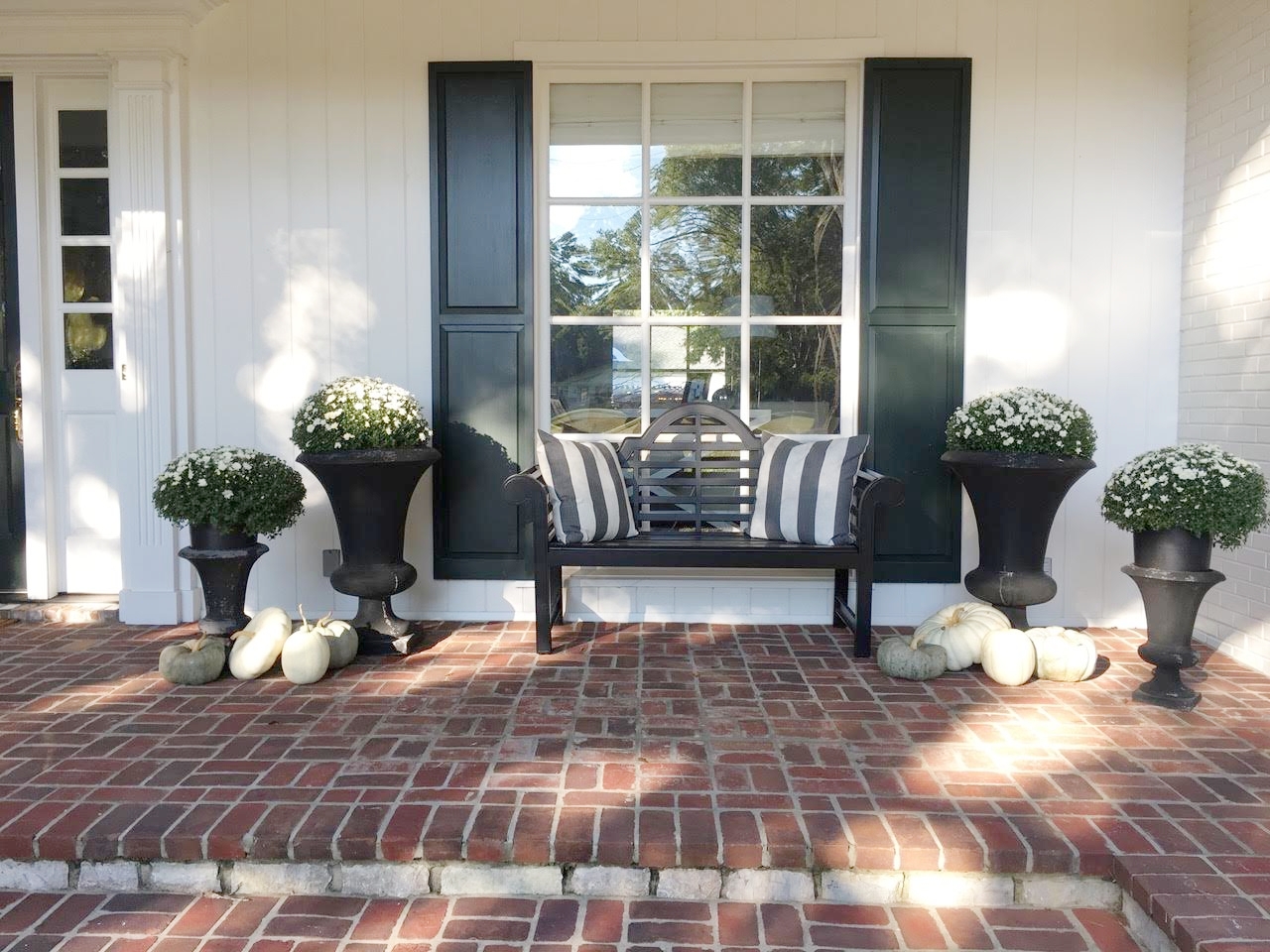  Fall Front Porch Decorations black bench with white mums and gray, white and green pumpkins 