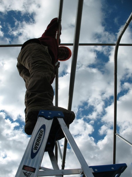 Balancing the (very tall) ladder for the (very precariously perched) farmer!