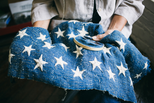 Harvesting_Liberty_Donnie-Hedden-23-Debra-Kriekel-hand-embroidering-the-stars-on-the-American-flag.jpg