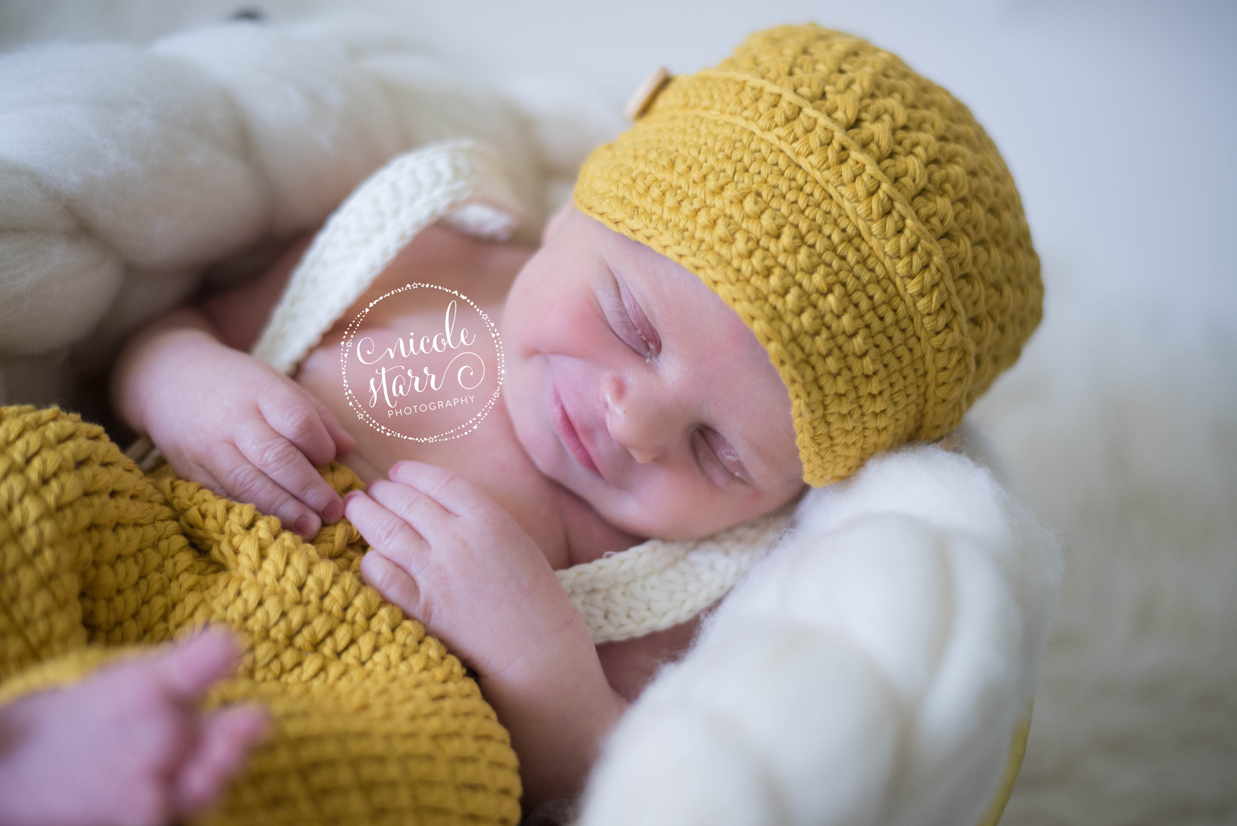 newborn photo with crocheted pageboy hat and suspenders and pants