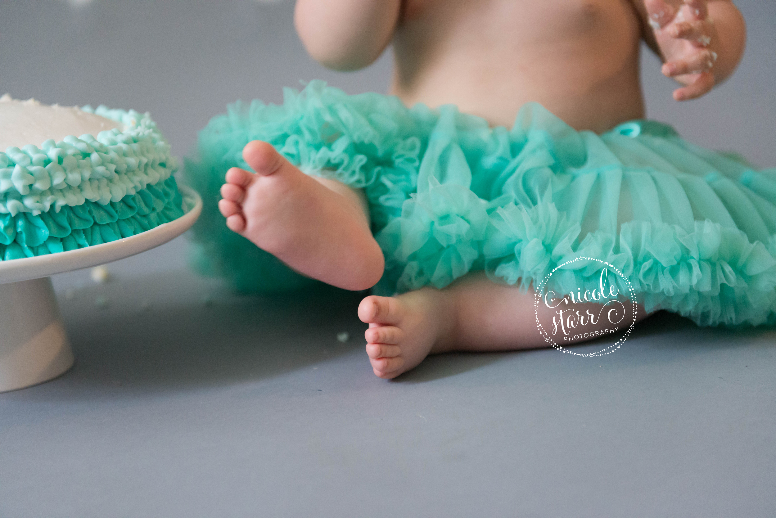 baby toes and birthday cake with teal tutu and teal frosting