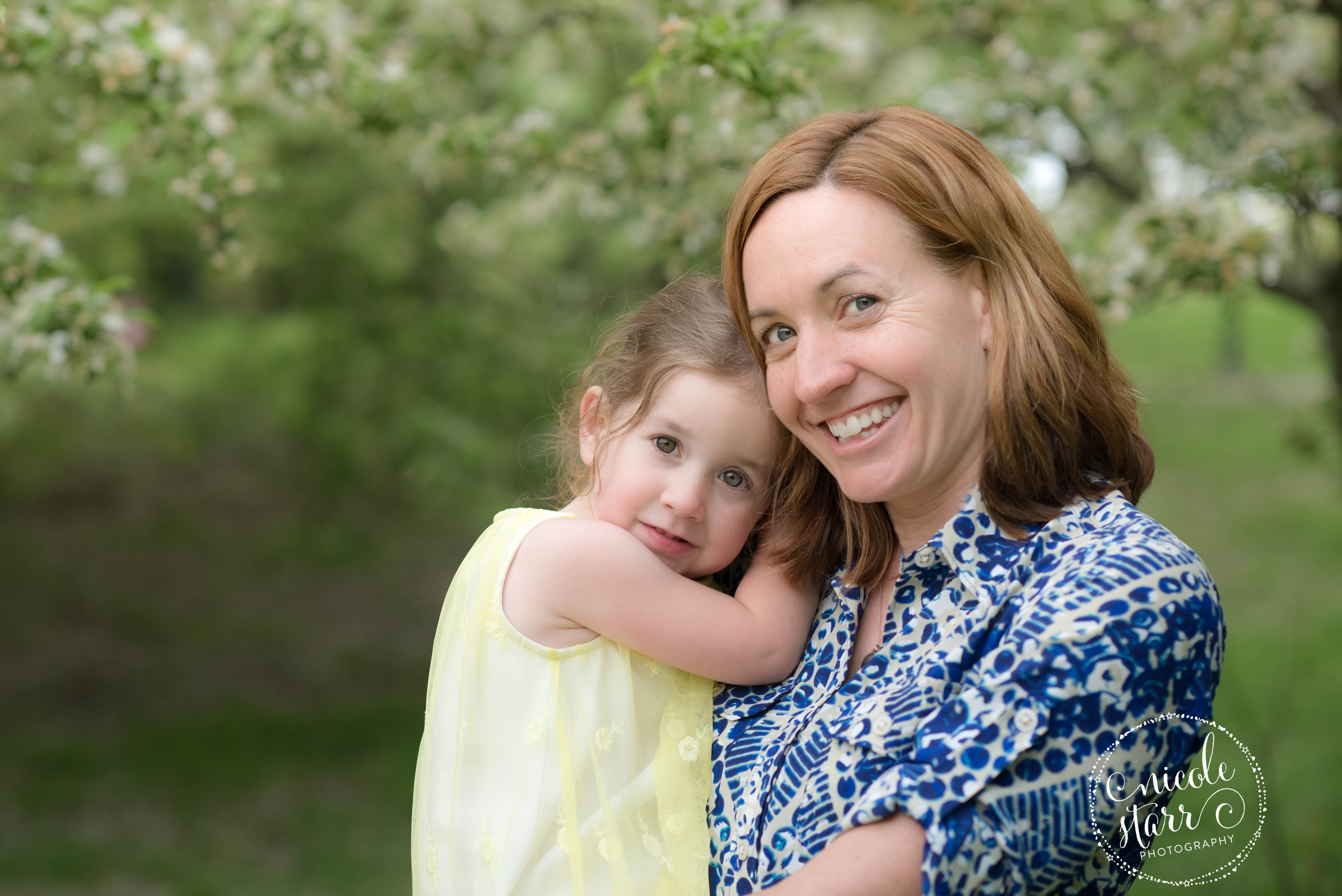 mother and daughter portrait with springtime blossoming tree
