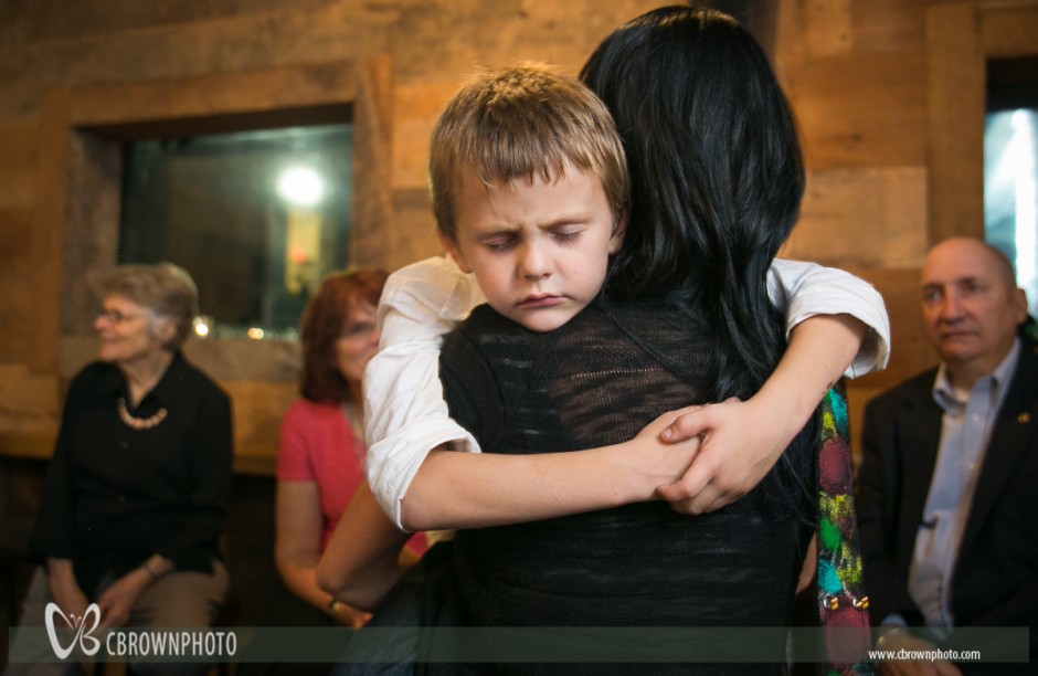 Youngster in Mom's arms near the end of wedding reception
