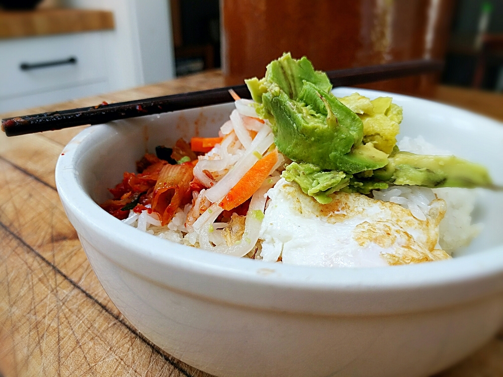 steamed white jasmine rice piled high with probiotic-rich homemade kimchi, pickled carrot and daikon, a fresh egg from our happy chickens and an avocado from our friends Ray and Barbara's tree.