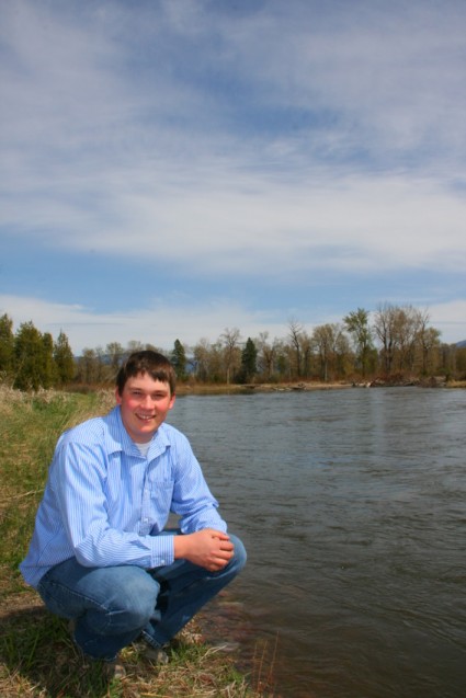 Senior portrait Luke in blue shirt by river