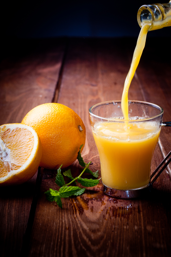 Orange and orange juice on a wooden background