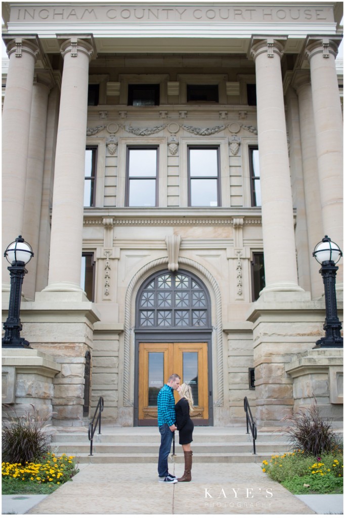 couple kissing in front of building, engagement 