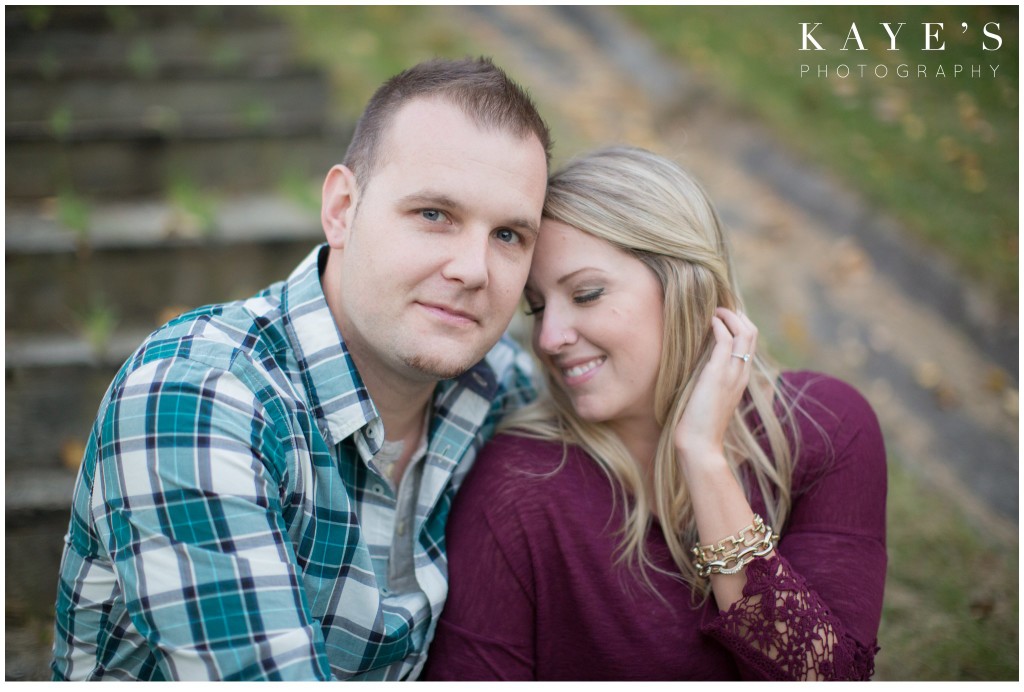 engagement session, couple, cuddle, woman tucking hair behind ear