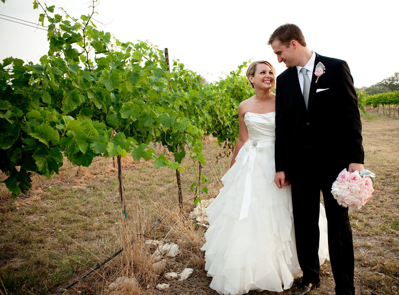 bride and groom holding hands and walking in the vineyard