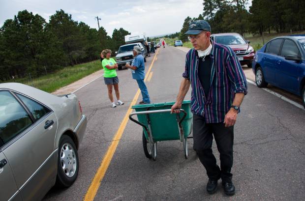 Mitch Slate, who lives on the unevacuated side of Burgess Road, spent four hours handing out more than six cases of water to residents waiting to be escorted into the Black Forest burn area Saturday, June 15, 2013. Michael Ciaglo/The Gazette