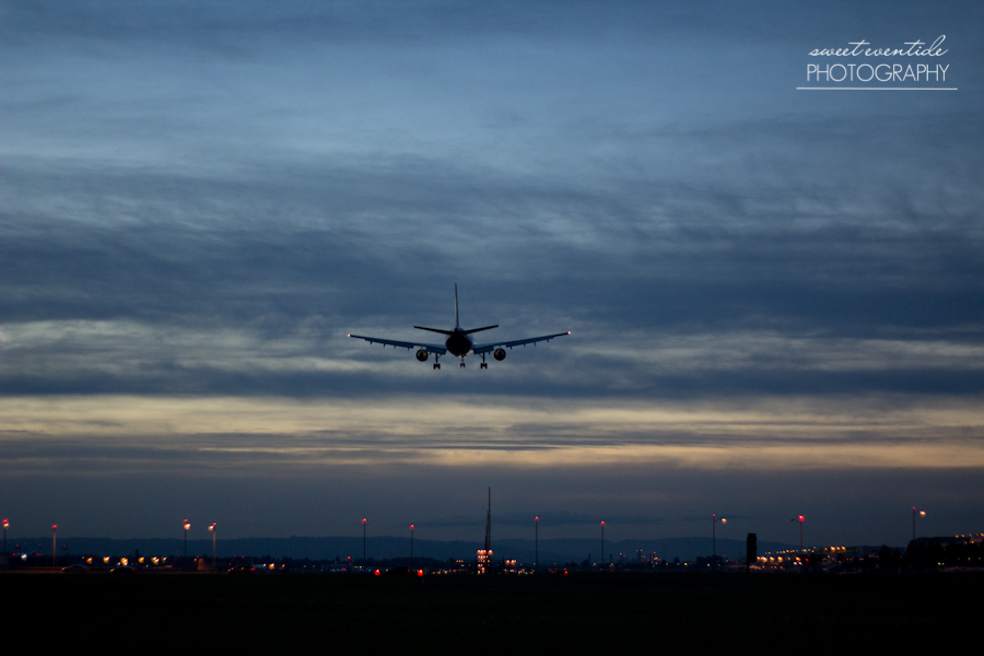 photograph of an airplane landing at portland international airport dusk