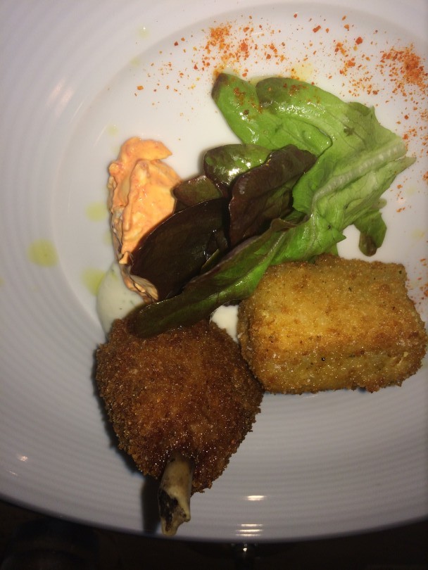Chicken wing with fried green tomato salad, buttermilk nage, and onion scapes