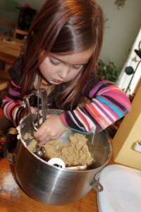 child scooping cookie dough