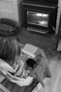 child warming themselves in front of fireplace