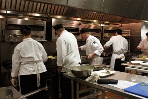 culinary students finishing dishes at the stove