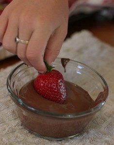 child dipping strawberries