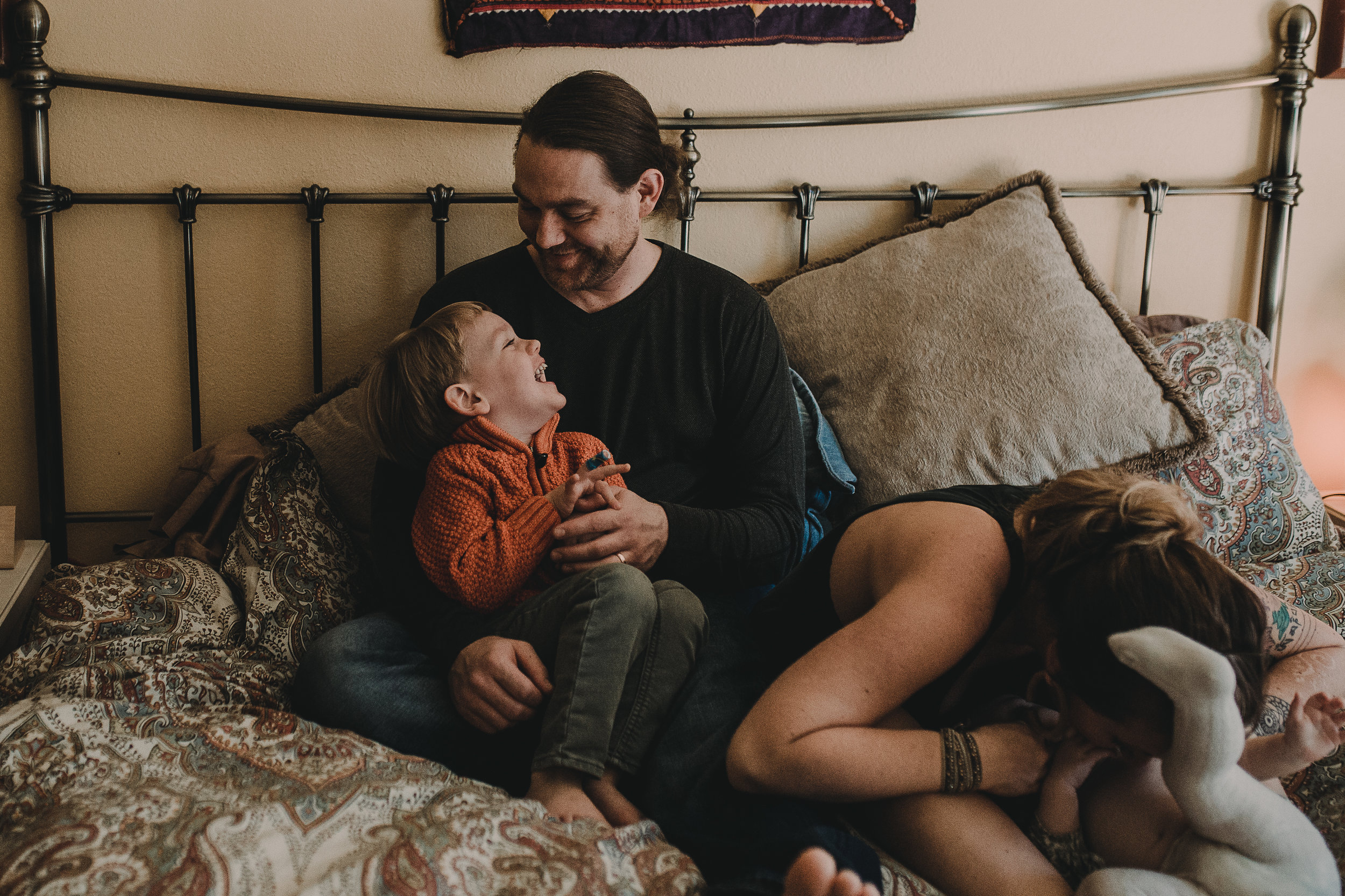  Family on bed boy laughing at Dad 