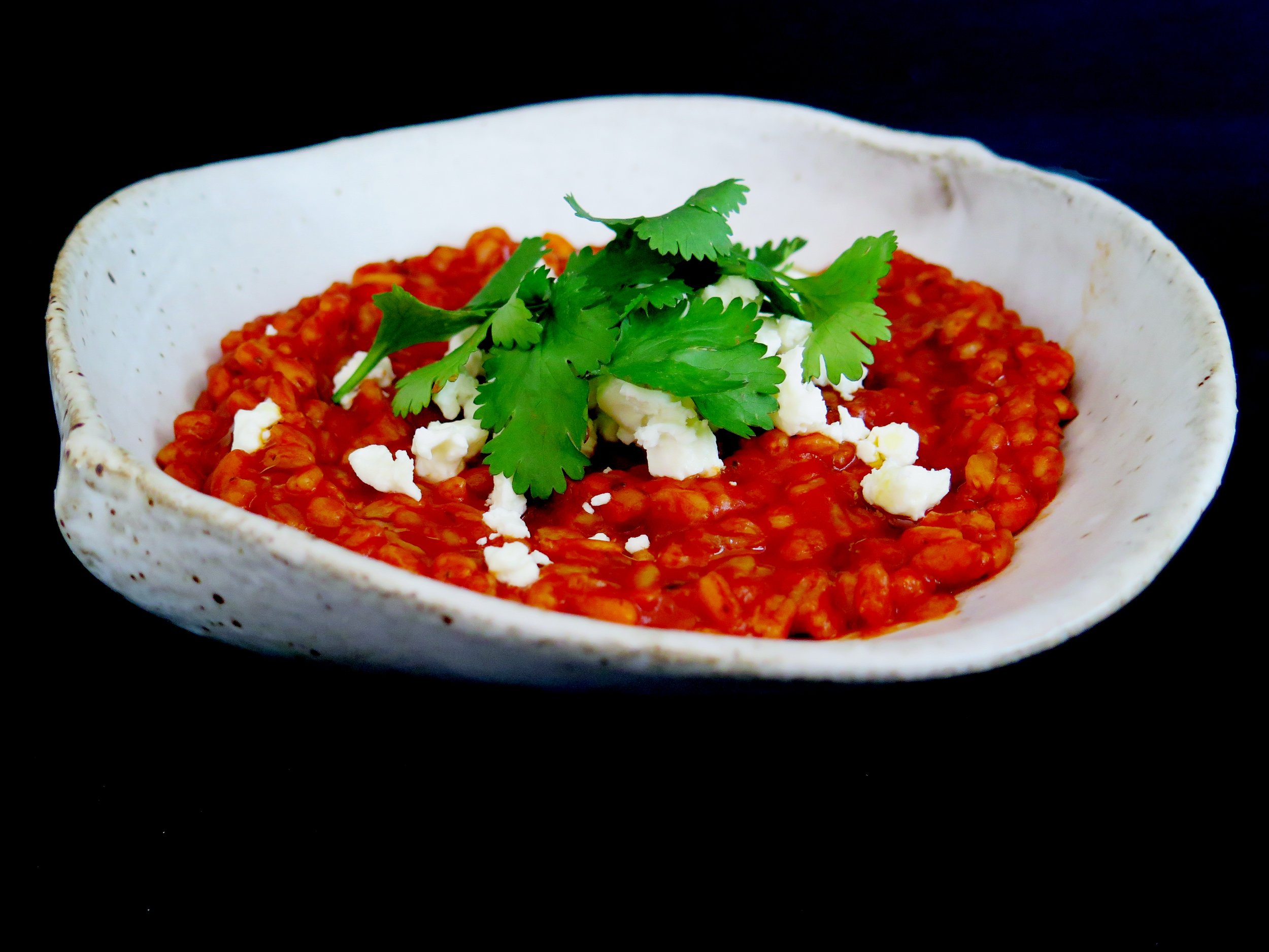Smoky tomato and garlic spelt risotto with crumbled feta and pine nuts