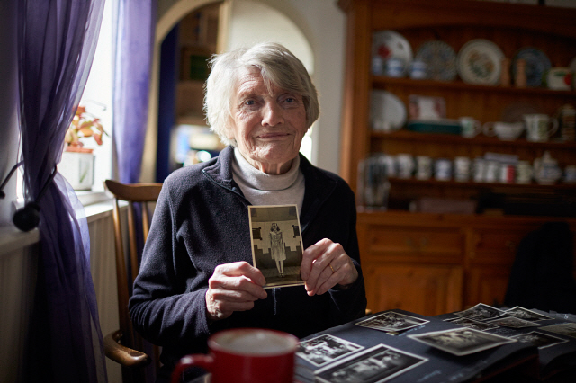 Senior Woman Holding Photo Of Her Younger Self
