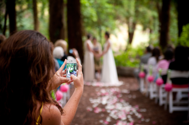 Wedding guest taking photo down the aisle