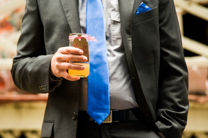 Detail of wedding guest with cocktail and blue tie