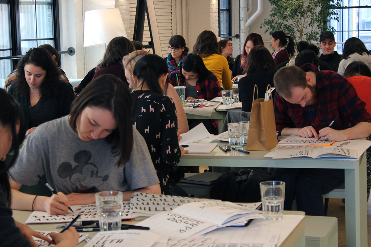 Students learning brush lettering in toronto
